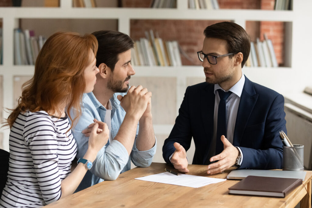 Interested young family couple visiting financial advisor in office