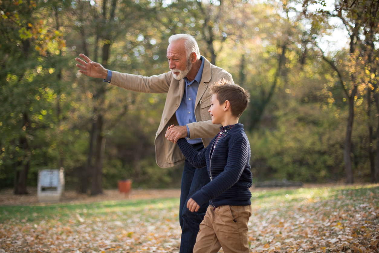Grandfather playing in park with grandson
