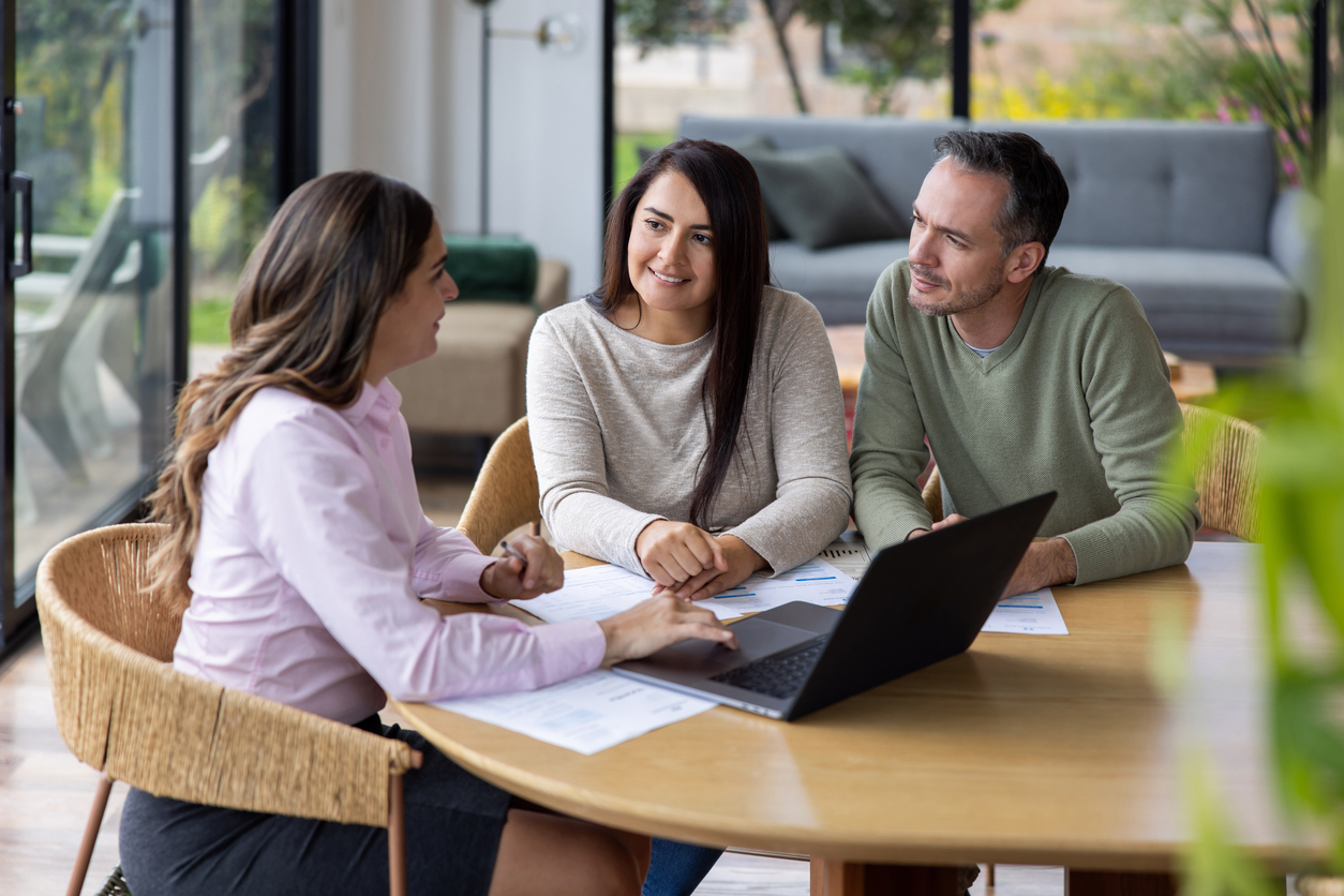 Financial advisor talking to a couple at their house about their home finances